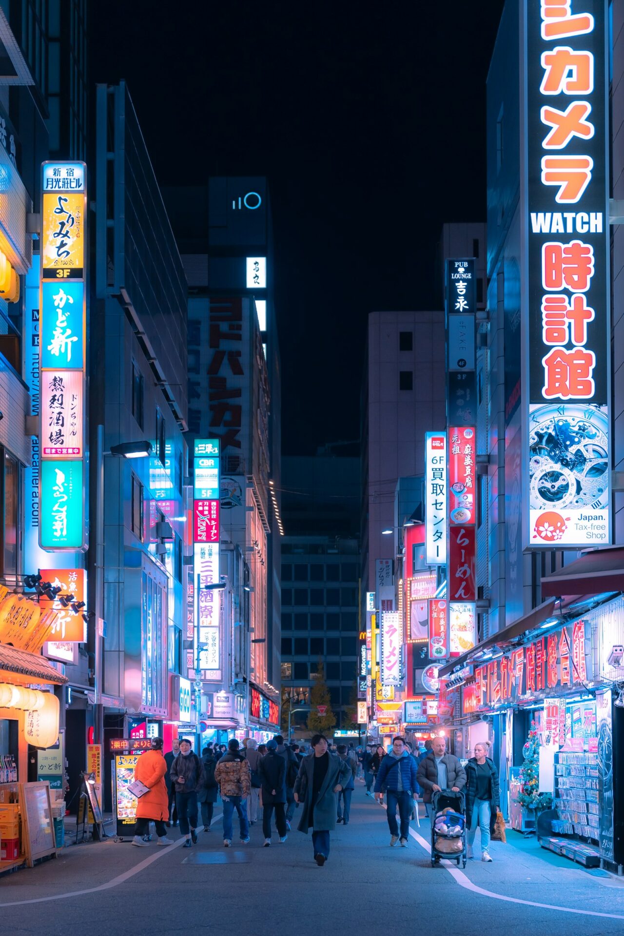 Rua movimentada no Japão à noite, repleta de letreiros e placas de neon disputando a atenção